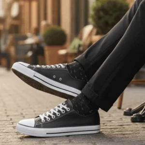 Tênis Star Couro Versátil e Confortável. Pessoa usando Tênis Star Couro Preto com calça de sarja preta e meia estampada em ambiente externo.