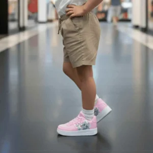 Tênis Infantil Casual Stitch Forcee - Conforto e Estilo escolar. Vista lateral de criança caminhando em um shopping usando Tênis Infantil Stitch Forcee na cor rosa pink, com meias brancas e shorts bege.